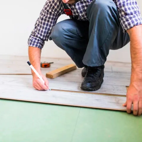 Una persona instalando un suelo de parquet